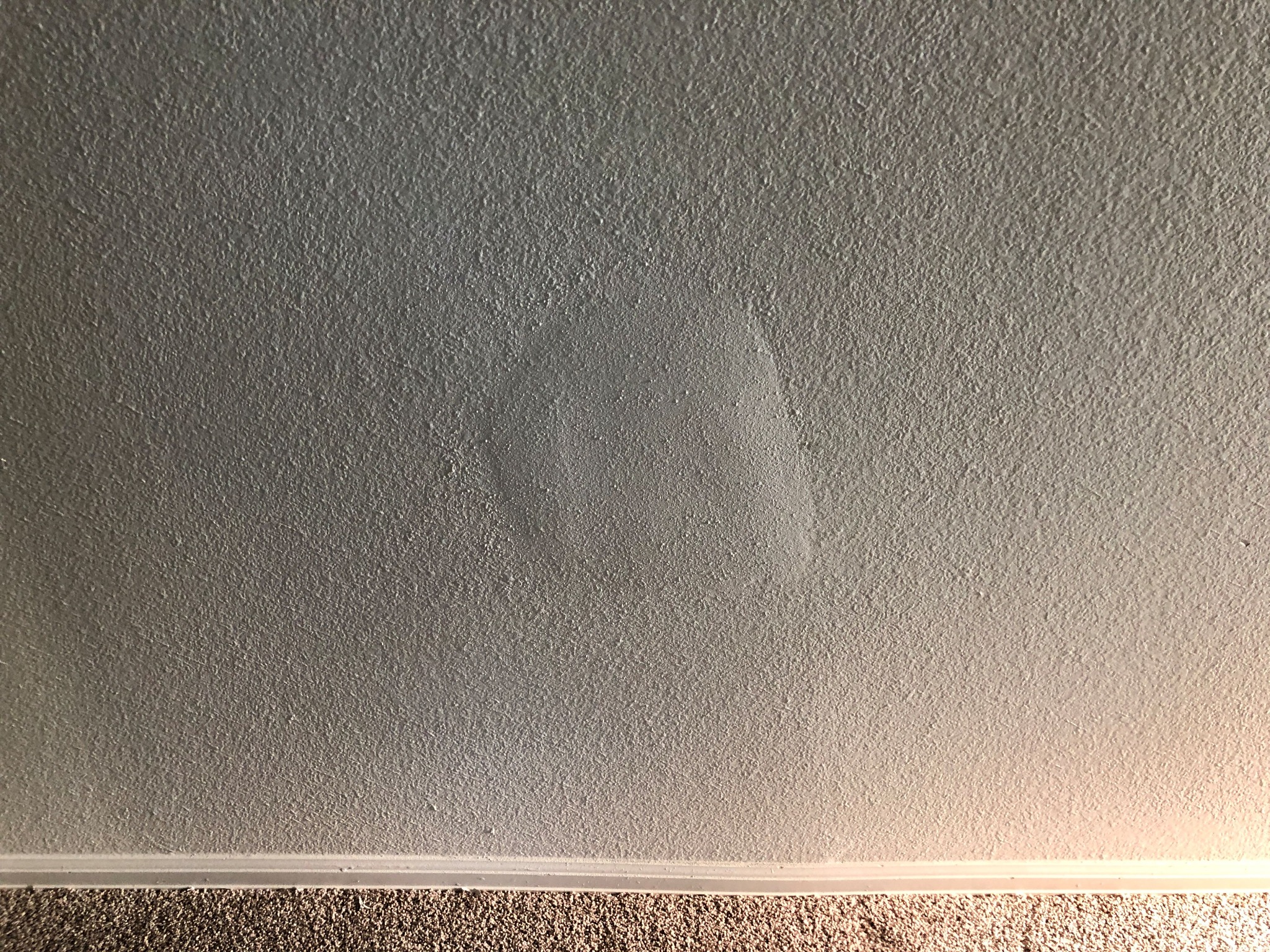 A visible drywall patch on a painted textured wall