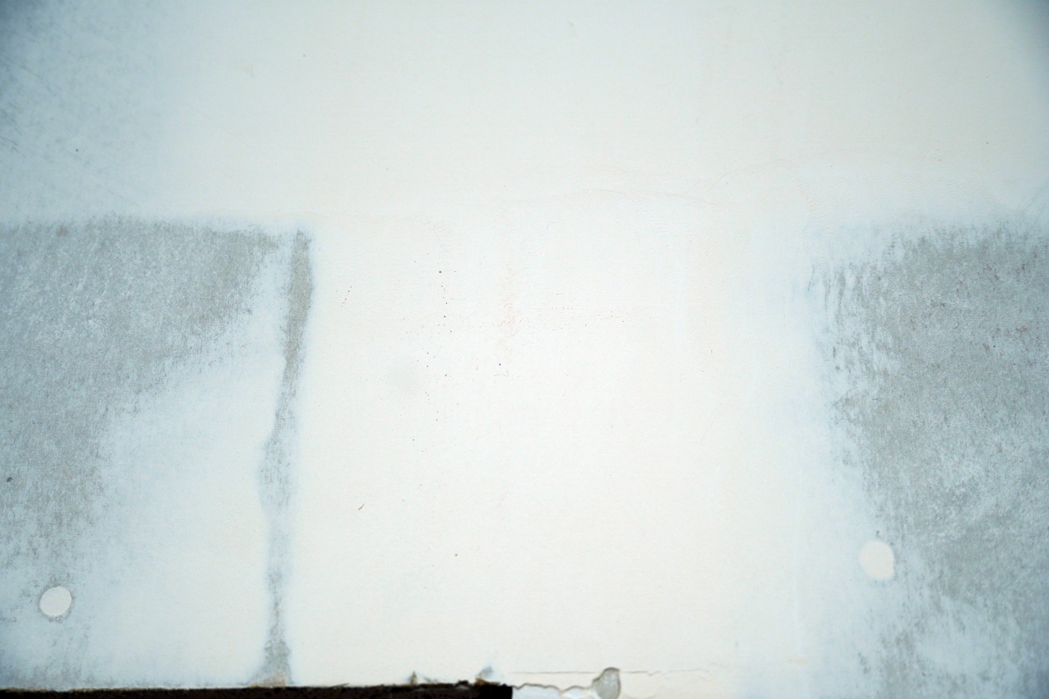 An oversanded recessed drywall joint with the board edges showing through the compound
